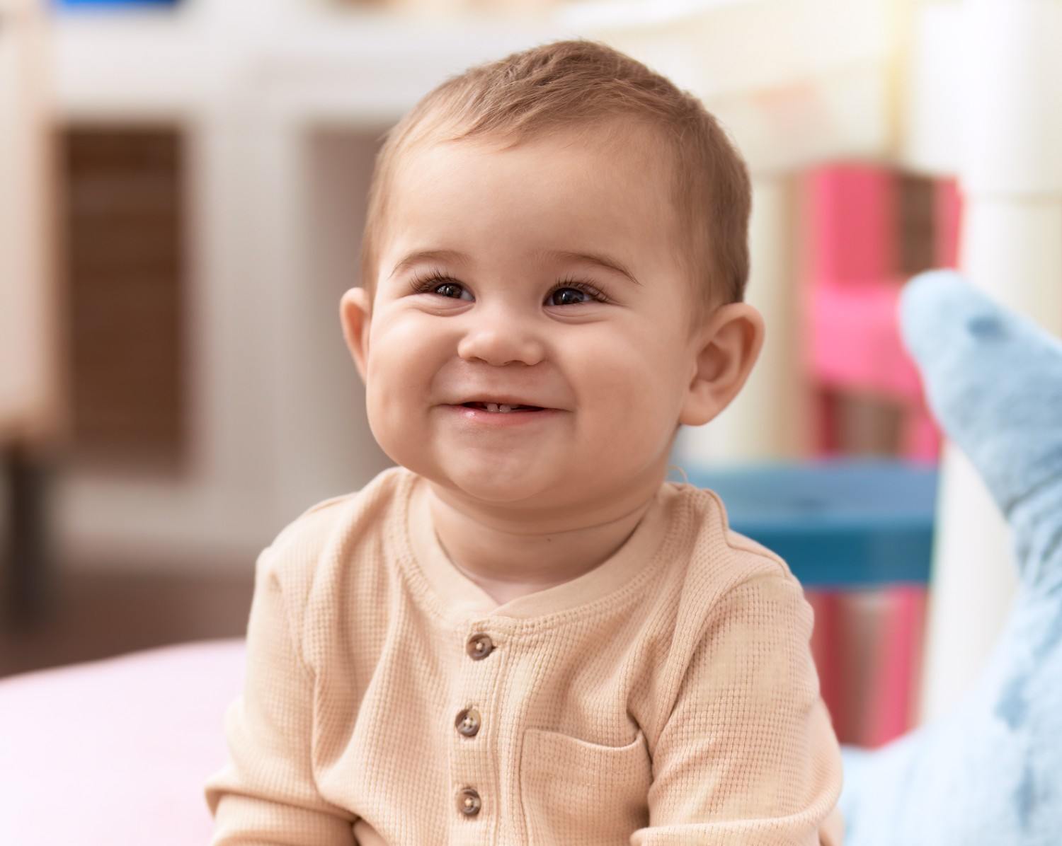 Smiling toddler sitting confidently at home