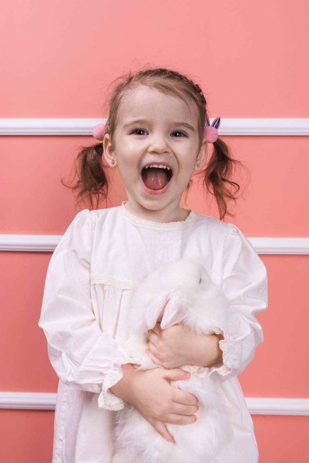 Amazed little girl standing with a toy rabbit, Sunshine KiDDS Dentistry