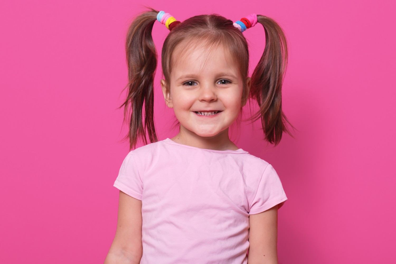 Cheerful little girl with pigtails smiling