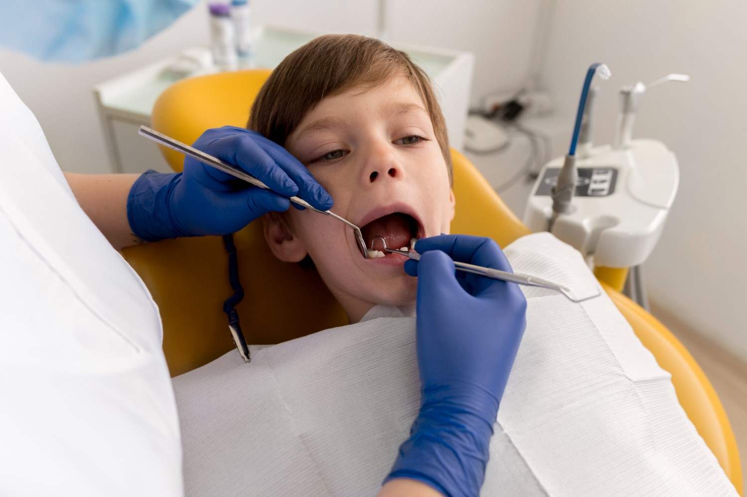 Dentist cleaning a child's teeth at Sunshine KiDDS Dentistry