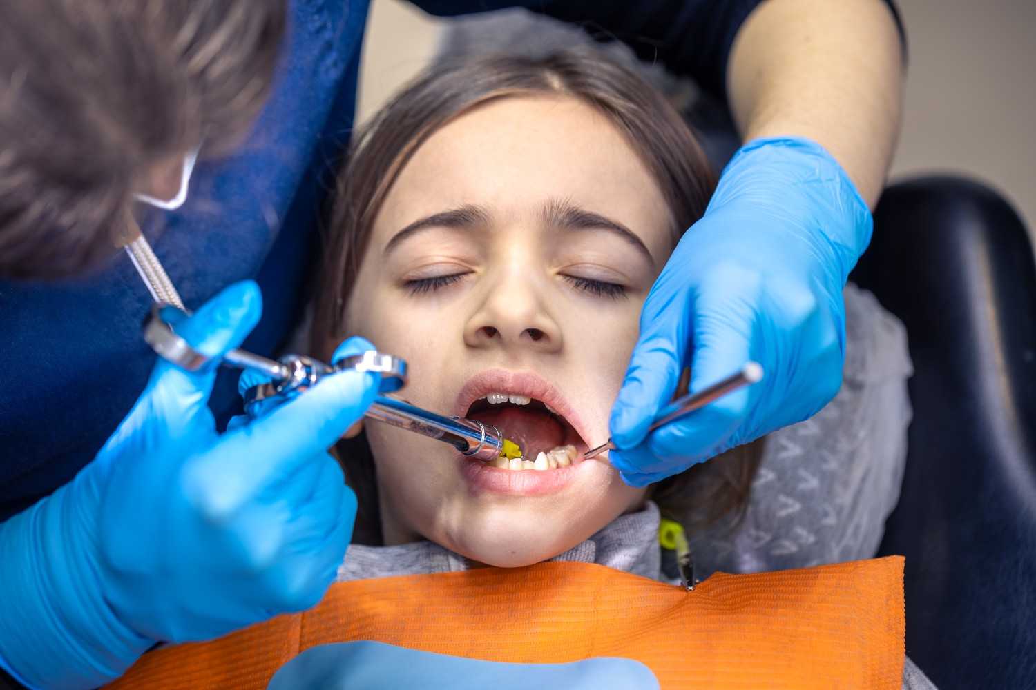 Dentist examining a young patient's teeth