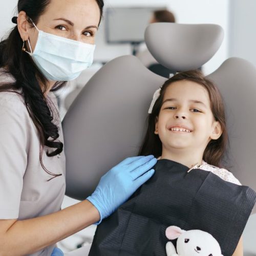 Pediatric dentist explaining dental sedation to a child and parent at Sunshine KiDDS Dentistry